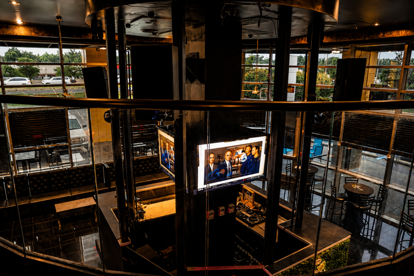 The upper level of Cross Ultra Lounge at dusk, brass railings and warm light